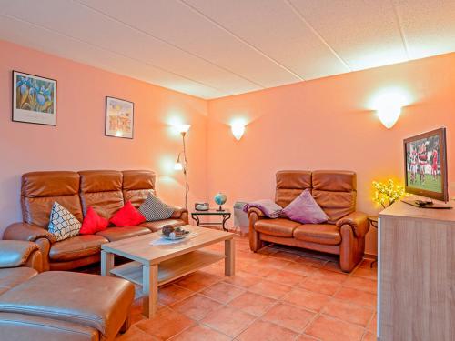 a living room with two couches and a table at Fischerhaus Rechlin in Zielow