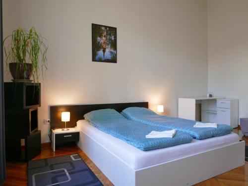 a bedroom with a large bed with blue sheets at Choco Home & Hostel in Cluj-Napoca