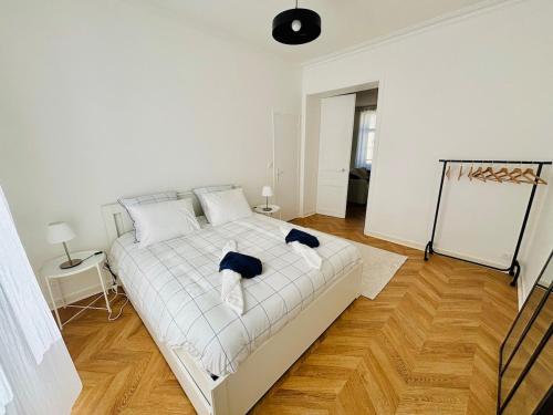 a bedroom with a white bed and a wooden floor at Élégance et modernité à proximité de la cathédrale in Quimper