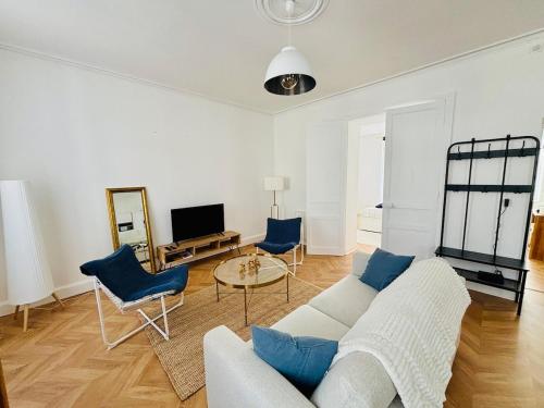 a living room with a white couch and blue chairs at Élégance et modernité à proximité de la cathédrale in Quimper