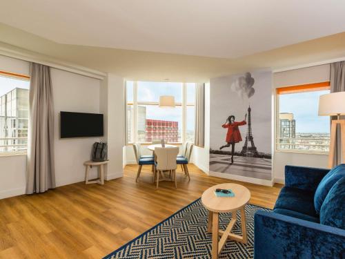 a living room with a blue couch and a table at Aparthotel Adagio Paris Centre Tour Eiffel in Paris