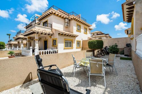 a patio with a table and chairs in front of a house at Siam's House in Villacosta