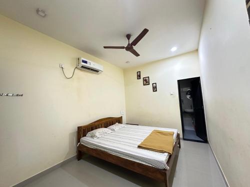 a bedroom with a bed and a ceiling fan at Sai Homestay Tarkarli in Malvan