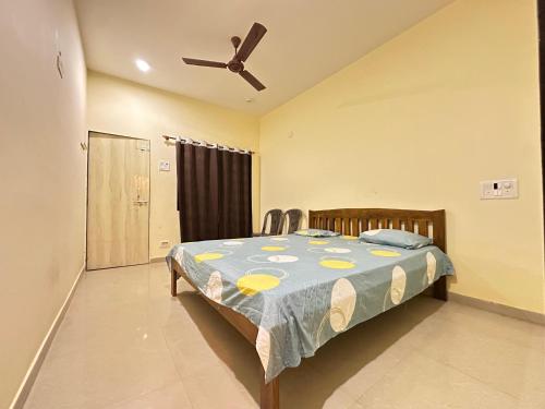a bedroom with a bed and a ceiling fan at Sai Homestay Tarkarli in Malvan