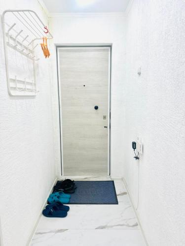 a room with a door and shoes on the floor at City in Uralsk