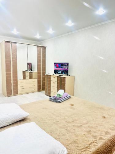 a room with a bed and a tv in it at City in Uralsk
