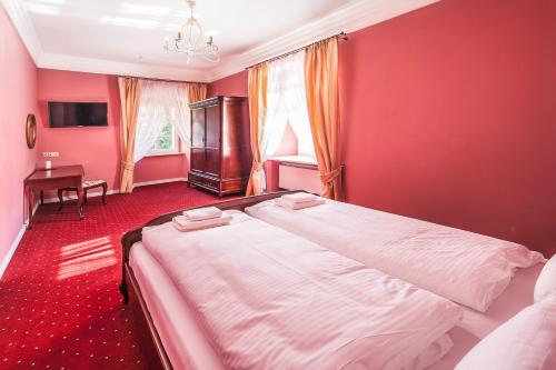 a bedroom with a large bed with red walls at Pałac Łagów in Zgorzelec