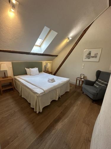 a bedroom with a large bed and a chair at Flädie Mat & Vingård in Flädie
