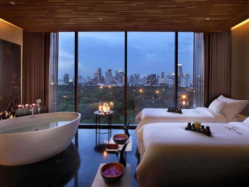 a hotel room with two beds and a bath tub at SO/ Bangkok in Bangkok