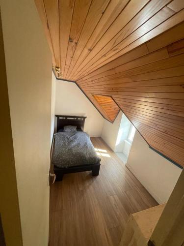 a bedroom with a bed in a room with a wooden ceiling at Charmante maison de campagne in Commana