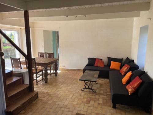 a living room with a couch and a table at Charmante maison de campagne in Commana