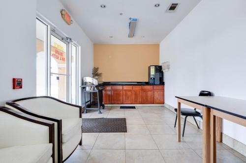 a living room with a table and a kitchen at Capital O Deluxe Inn Channelview Houston I-10 in Channelview