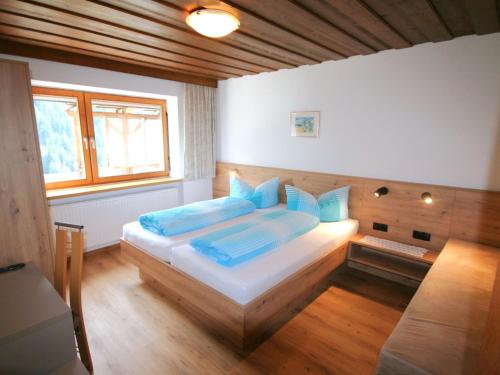 een slaapkamer met een groot bed met blauwe kussens bij Apartment Hedwig Jäger by Interhome in Kappl