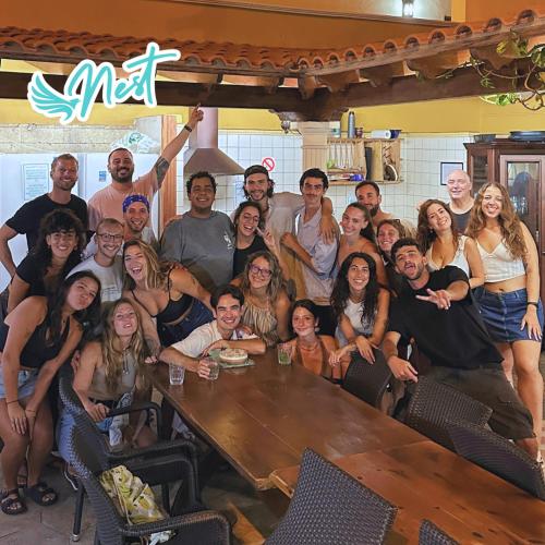 a group of people posing for a picture at a table at Duque Nest Hostel in Adeje