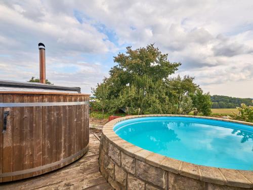 ÚhlejovにあるHoliday Home Růžovka by Interhomeの木製のフェンスの隣にある擁壁のプール