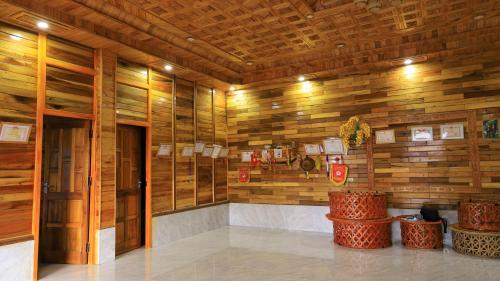 a room with wooden walls and a lobby with stools at Homstay Páo Ấm Mai in Tát Lá