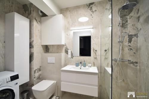 a bathroom with a toilet and a sink and a shower at Apartament Szmaragd&Perła by LookAp - parking gratis! in Poznań