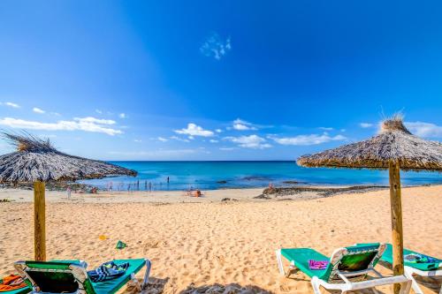 two beach chairs and umbrellas on a beach at SBH Costa Calma Beach Resort Hotel in Costa Calma