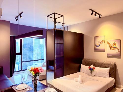 a bedroom with a bed and a table with flowers on it at AXON RESIDENCE BUKIT BINTANG KLCC by FIRST CLASS in Kuala Lumpur