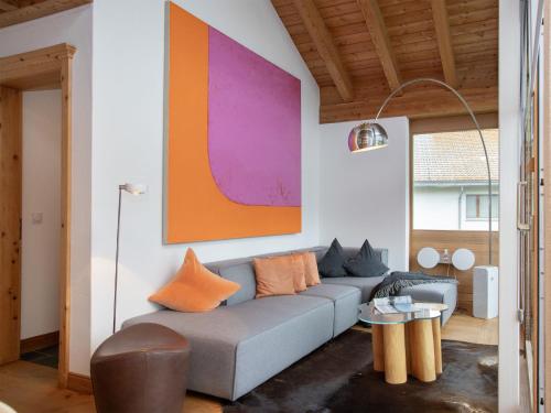 a living room with a couch and a colorful painting at Apartment Chesa Vadret 12 by Interhome in Pontresina