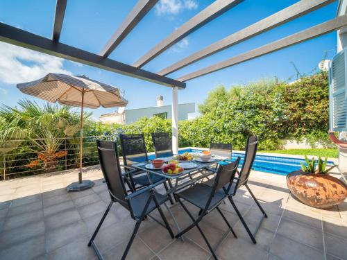 eine Terrasse mit Tisch und Stühlen und einem Pool in der Unterkunft Villa Amanecer by Interhome in Alcúdia