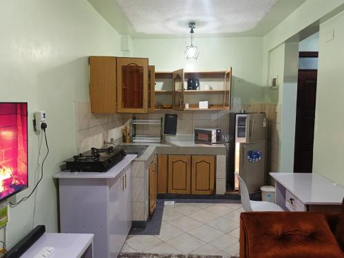a kitchen with wooden cabinets and a stove top oven at Legatus Cozy Homes Ngong in Ngong