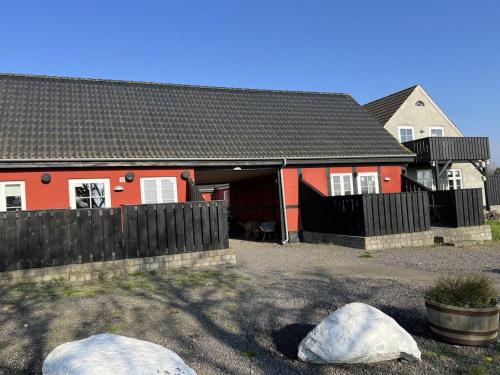 a red house with two rocks in front of it at Apartment Lutz - 6km from the sea by Interhome in Åkirkeby