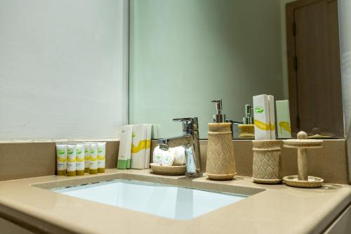 a bathroom counter with a sink in front of a mirror at Relaxed Luxe Studio - Elegant City Escape in Abu Dhabi
