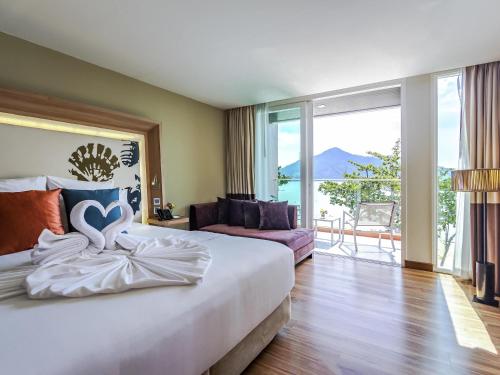 Un pat sau paturi într-o cameră la Novotel Phuket Kamala Beach