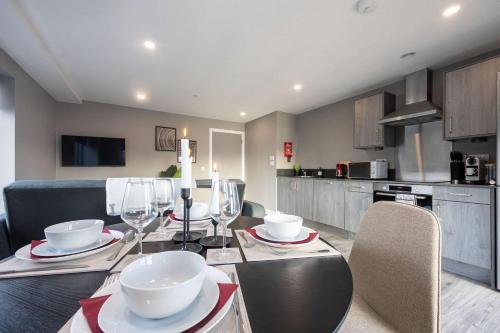 a kitchen with a dining table with wine glasses at Stunning Liverpool Dockside Apt by City SuperHost in Liverpool