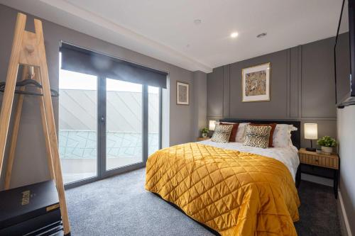 a bedroom with a bed with a yellow blanket and a ladder at Stunning Liverpool Dockside Apt by City SuperHost in Liverpool