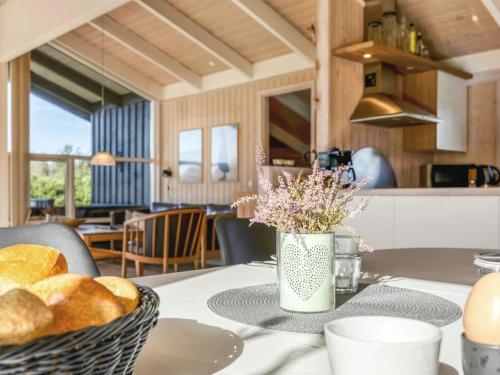 a table with bread and a basket of flowers on it at Holiday Home Asol - 650m from the sea by Interhome in Løkken