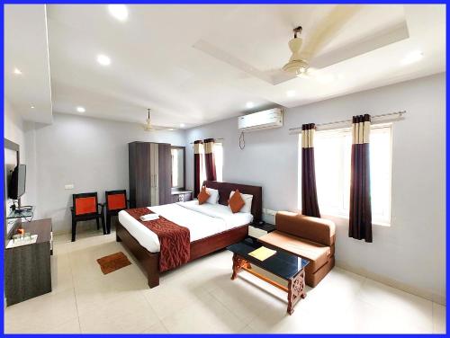 a bedroom with a bed and a chair and a couch at Rooftop Sea View Boutique Shivangi Hotel Near Jagannath Temple 1400m - Restaurant- Lift and Free Parking Facilities - Fully Air Conditioning Premium Rooms- Best Sea Beach Hotel In Puri in Puri