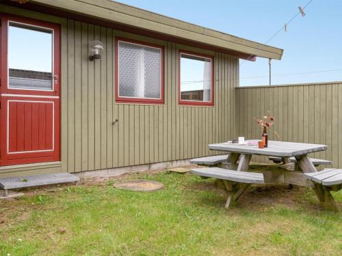 a picnic table in front of a house with a red door at Holiday Home Siv - from the sea by Interhome in Bjerregård