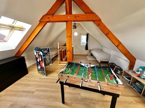 a room with a table in the middle of a attic at Duplex familial lumineux , Plage à deux pas in Berck-sur-Mer