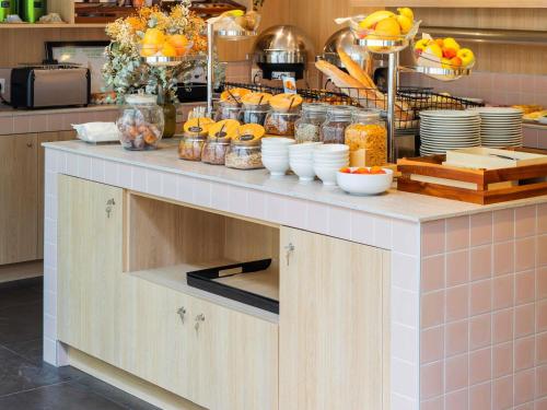 a kitchen with a counter with food on it at Mercure Président Biarritz Plage in Biarritz