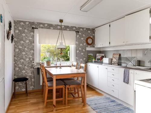 a kitchen with white cabinets and a wooden table at Holiday Home Skjutsmåla by Interhome in Olofström