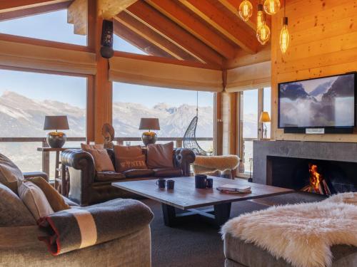 een woonkamer met open haard en tv bij Chalet Chalet Gerritsen by Interhome in Nendaz