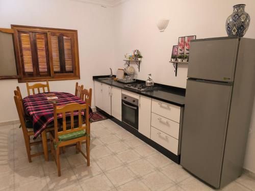 a kitchen with a refrigerator and a table and chairs at Younes résidence 3 in Asilah