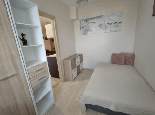 a small bedroom with a bed and a closet at Motylowa Przystań in Łódź