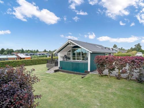 a house with a green shed in a yard at Holiday Home Panu - 2-1km from the sea by Interhome in Bogø By