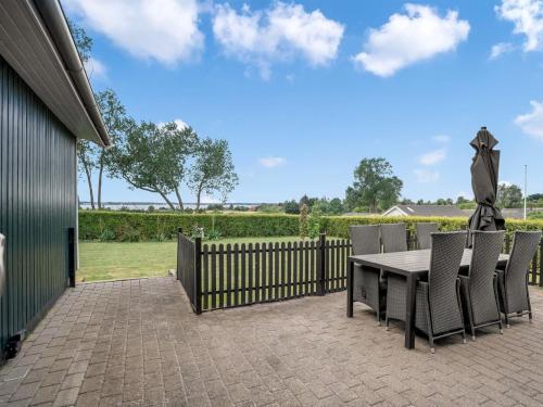 a patio with a table and chairs and a fence at Holiday Home Panu - 2-1km from the sea by Interhome in Bogø By