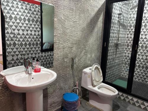 un baño con lavabo e inodoro en Guest House Bobonito, en Beira