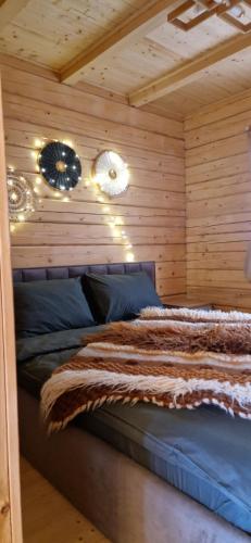 a bedroom with a bed in a wooden wall at Nice House in Maidan Village
