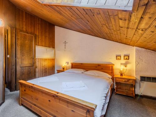 a bedroom with a large bed with a wooden ceiling at Apartment Mansarda al Doss by Interhome in Giustino