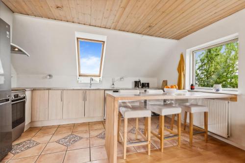 a kitchen with a large wooden table and stools at Entire Apartment with 2 Bedrooms and Private Patio in Dragør