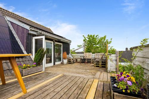 a wooden deck with a table and chairs on it at Entire Apartment with 2 Bedrooms and Private Patio in Dragør