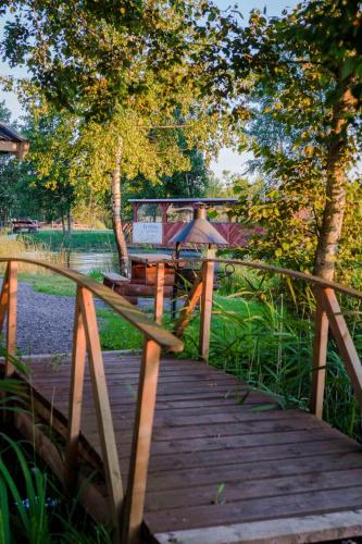 a wooden bridge with two benches and an umbrella on it at Ermistu Puhkeküla in Ermistu