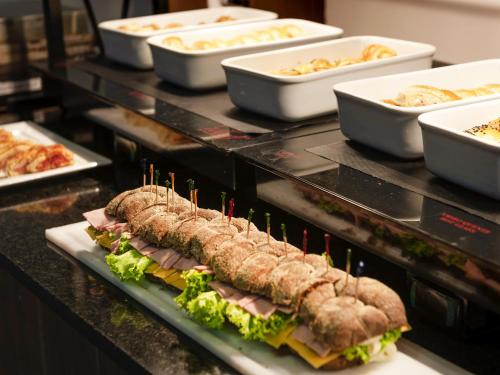 ノヴァ・イグアスにあるMercure Rio de Janeiro Nova Iguaçuのサンドイッチなどの食品を揃えたビュッフェ