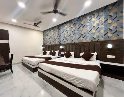 a bedroom with two beds and a wall at Hotel GS Grand Amritsar in Amritsar